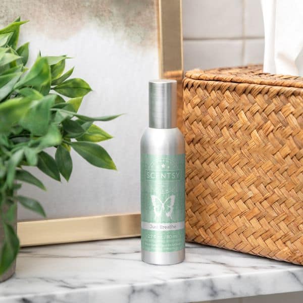 Scentsy Just Breathe Room Spray placed on a marble bathroom counter beside a woven tissue box and greenery. Elegant and simple way to freshen up any space instantly.