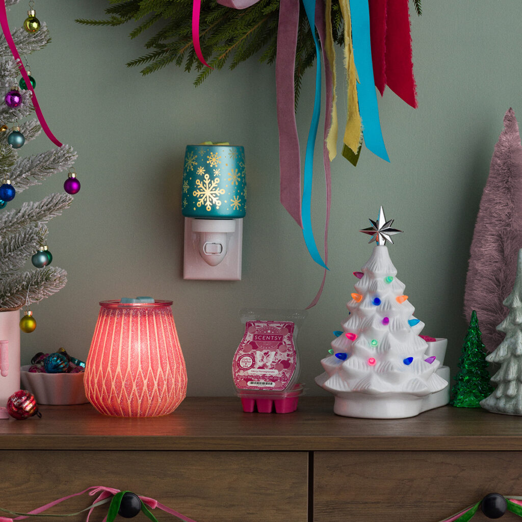 “The Merry & Bright collection Scentsy warmers displayed together with festive ribbon, colorful ornaments, and a retro ceramic Christmas tree. Perfect cheerful setup for holiday decorating and gifting.”