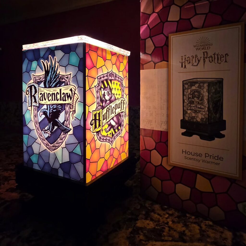 Harry Potter House Pride Scentsy Warmer featuring the four Hogwarts houses — Gryffindor, Hufflepuff, Ravenclaw, and Slytherin — in a stained-glass-style design with glowing light.
