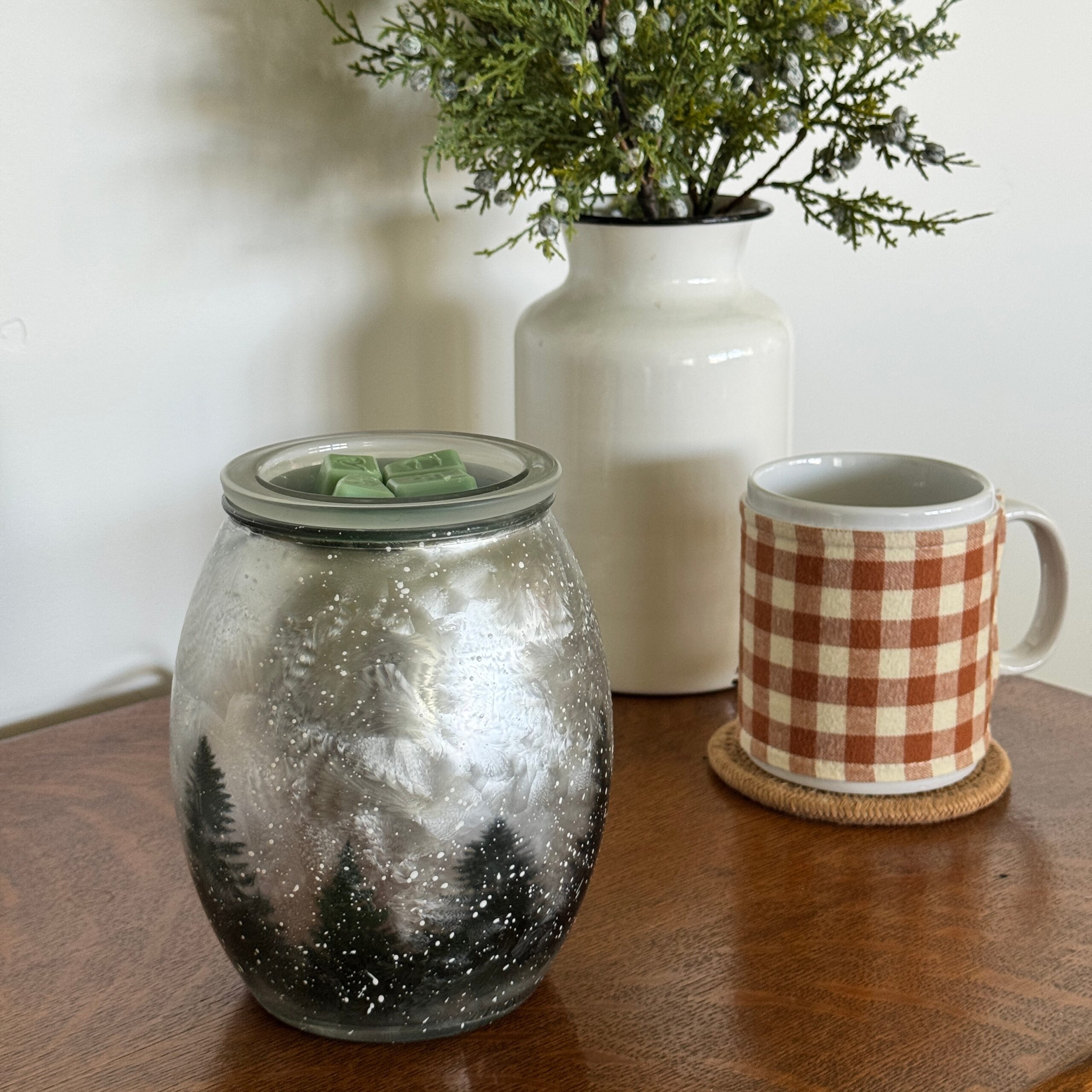 Unlit Scentsy Wintercrest Warmer on a table, showing the frosted glass and detailed evergreen tree design.