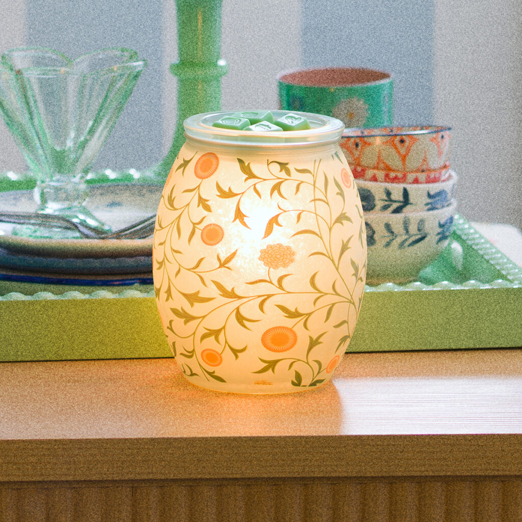 Sunny Vines Scentsy warmer glowing with a soft yellow light and floral vine pattern, styled on a kitchen counter.