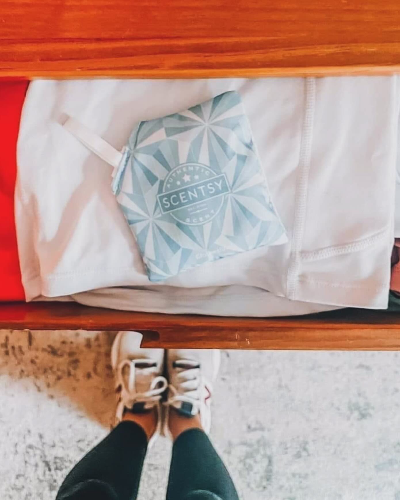 Hand holding a Scentsy Jammy Time scent pak inside a soft blanket, demonstrating how scent paks can keep linens and blankets smelling fresh.