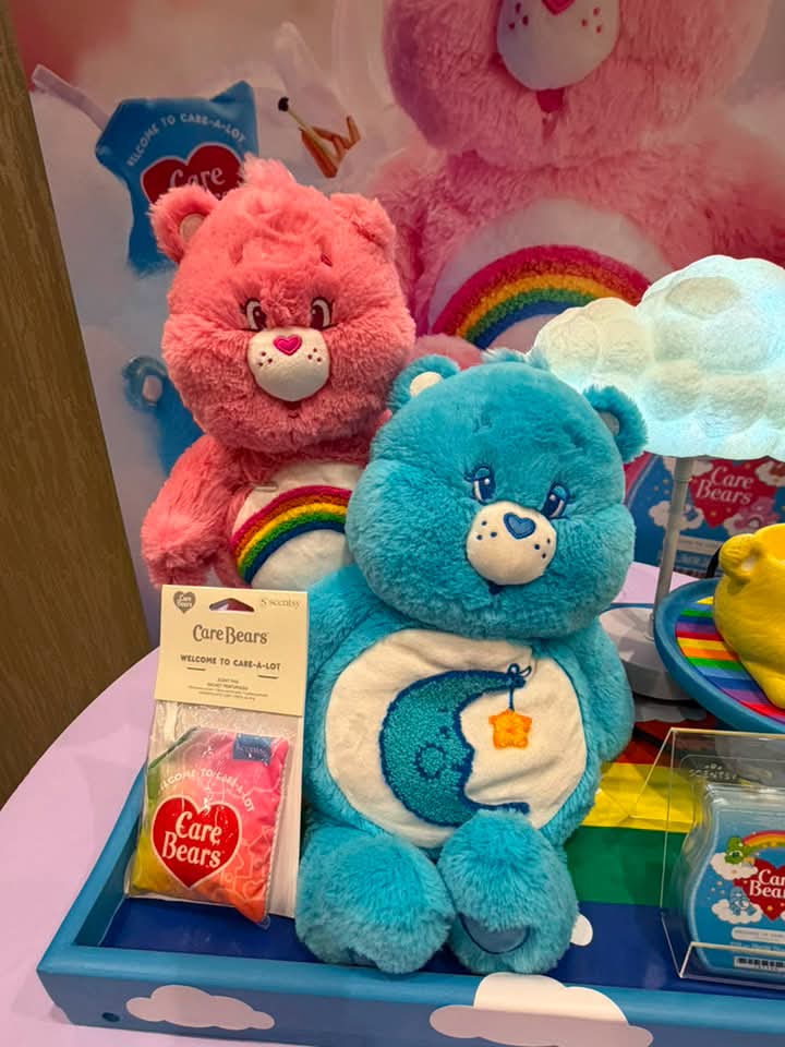 Scentsy Care Bears Cheer Bear Buddy and weighted and warming Bedtime Bear displayed with the Care Bears Collection.