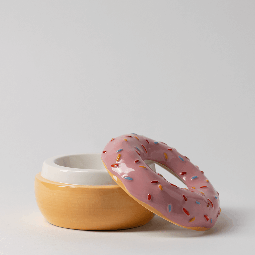 Scentsy Pink Sprinkle donut warmer. with red, blue and tan sprinkles with the lid off