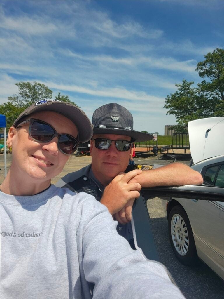 Amber Grillot and her husband Jeremy smiling together outdoors while he is on duty as a law enforcement officer.