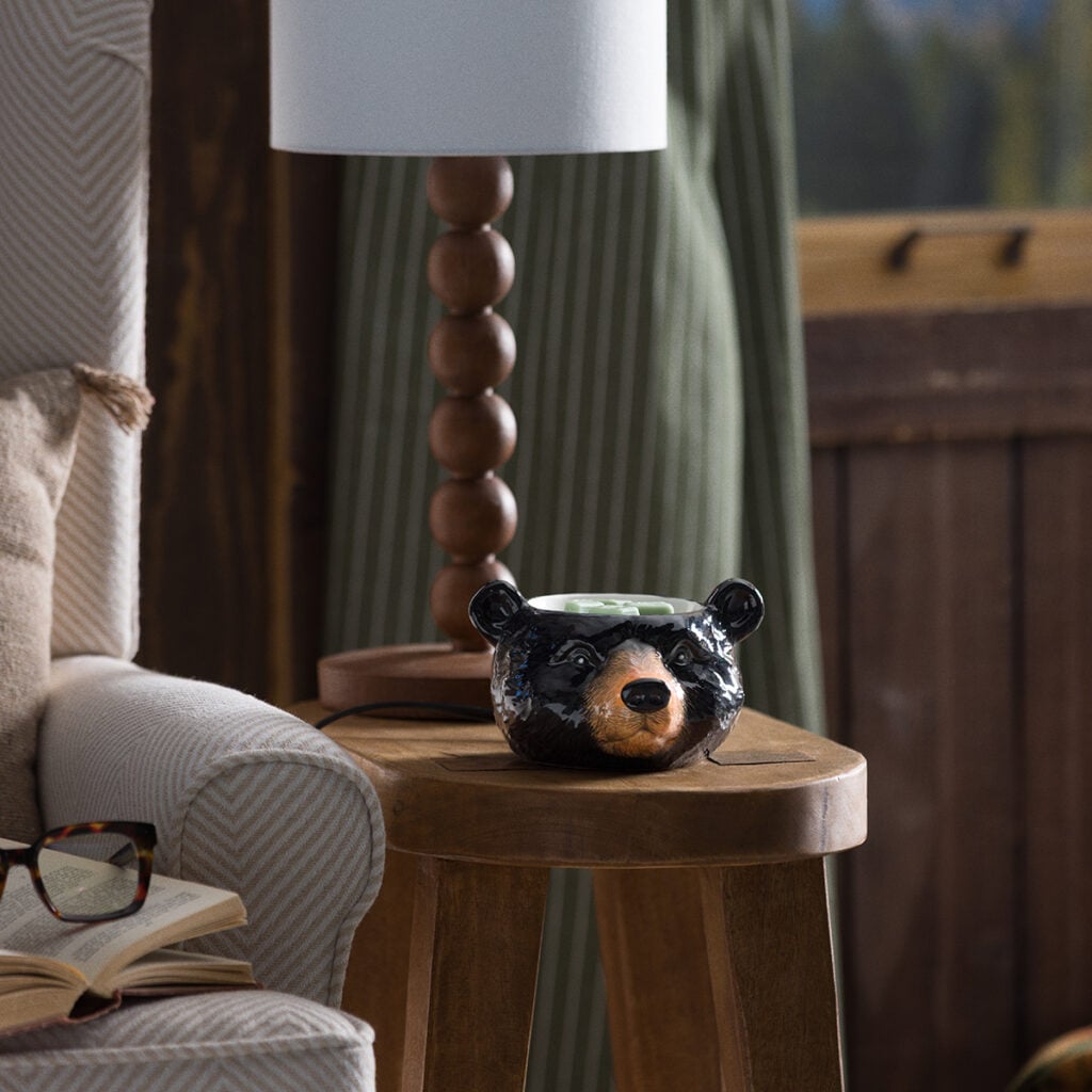 Blackwood Bear Scentsy Warmer featuring a black bear-shaped ceramic warmer with melted wax in a cozy cabin setting.