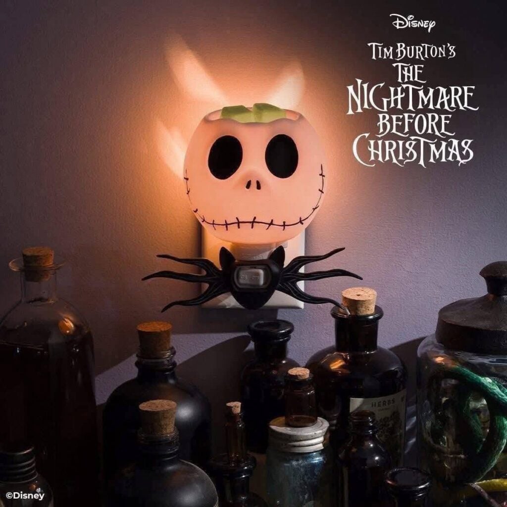 Disney Jack Skellington pumpkin Scentsy Mini Warmer glowing in a wall outlet, inspired by The Nightmare Before Christmas.