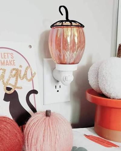 Pink iridescent glass Scentsy Mini Warmer, Petite Pumpkin Mini warmer, with a pumpkin-inspired shape and curled metal stem.
