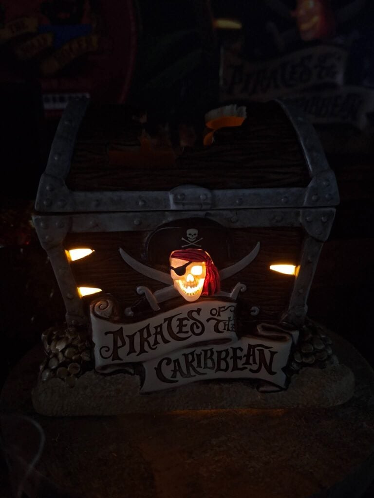 Disney Pirates of the Caribbean Scentsy warmer lit in a dark room with the glowing pirate skull detail.