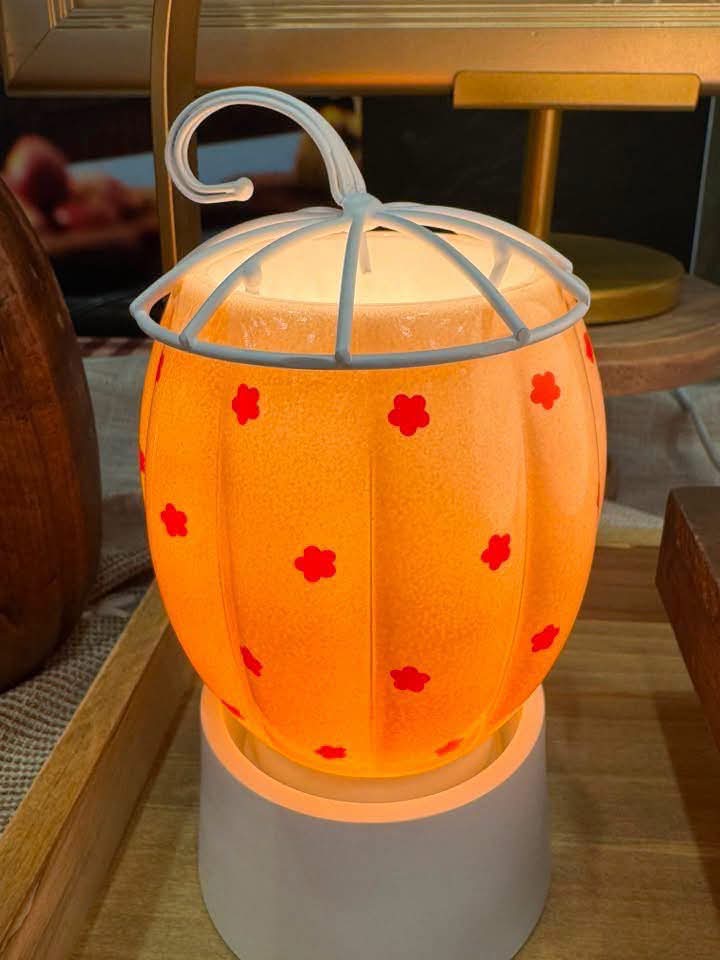 Glowing pumpkin, Pumpkin Posey Scentsy Mini Warmer with a white metal stem and scattered red floral dots