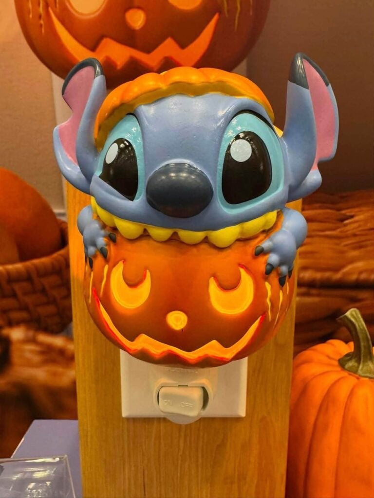 Disney Stitch Pumpkin Trouble Scentsy Mini Warmer featuring Stitch peeking out of a glowing jack-o'-lantern pumpkin.