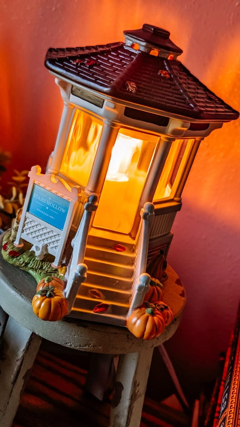 Welcome to Stars Hollow Scentsy Warmer glowing warmly with pumpkins and fall details around the gazebo.