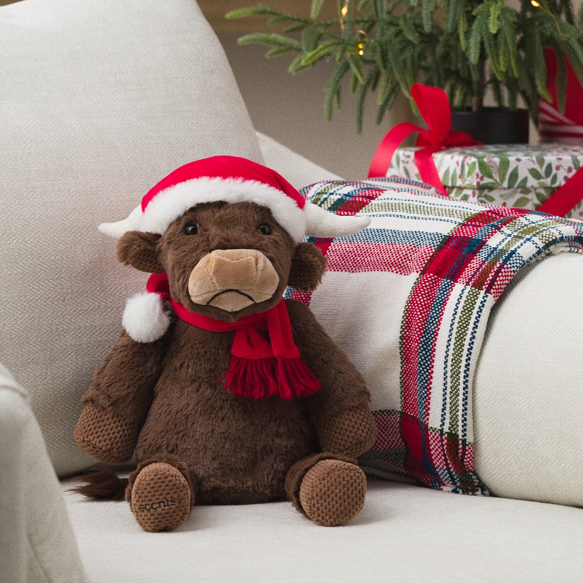 Scentsy Jolly Ol’ Saint Moo Buddy wearing a red Santa hat and scarf for the 2026 Holiday Collection.