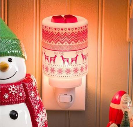 Lit Scentsy Nordic Winter Mini Warmer featuring red Nordic-style reindeer and snowflake patterns.
