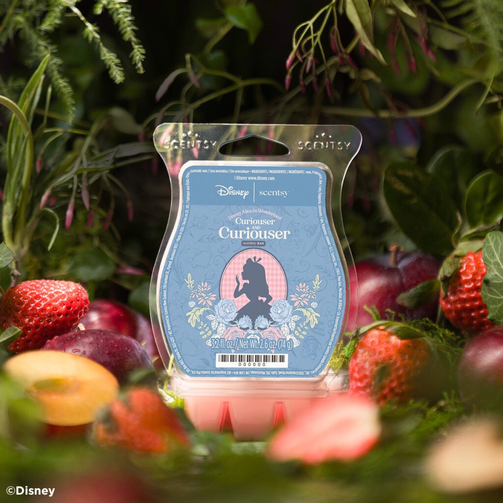 Disney Alice in Wonderland Curiouser and Curiouser Scentsy Bar with pink wax and Alice-themed packaging, surrounded by strawberries, fruit and greenery.