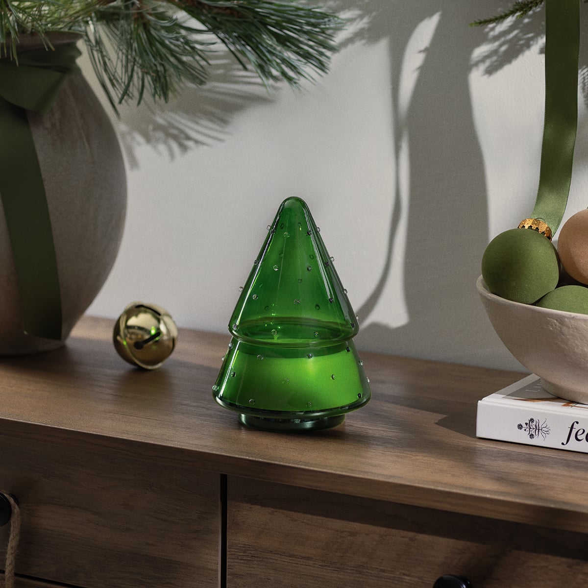 Green Christmas tree-shaped Iced Balsam Scentsy Scented Candle displayed with pine branches and holiday ornaments.