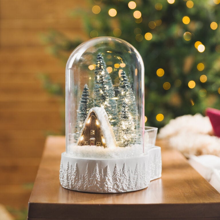 Magic of Winter Scentsy Warmer featuring a snowy cabin and illuminated evergreen trees inside a glass dome with a white forest-themed base.
