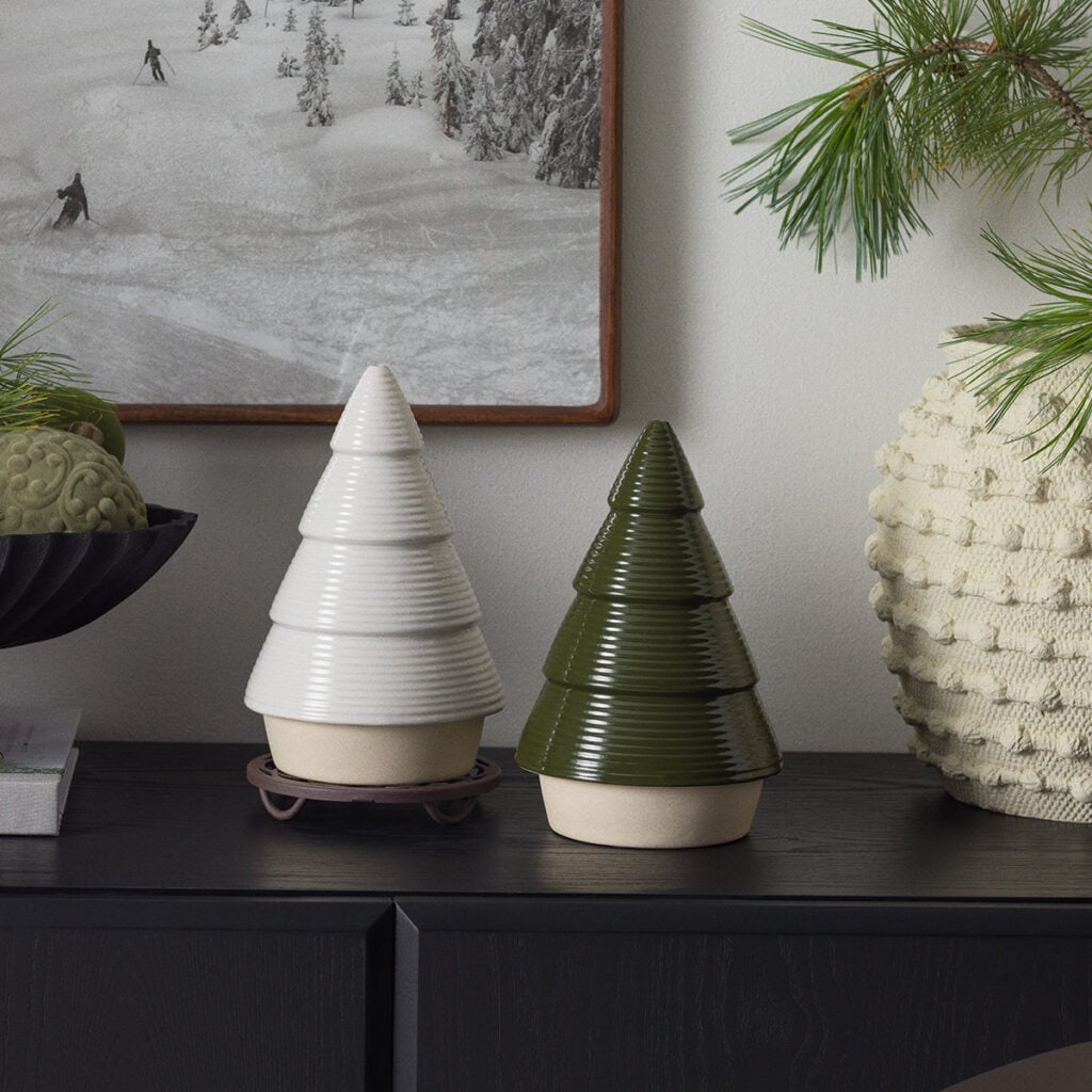 White and forest green Nordic Pine Scentsy Warmers shaped like Christmas trees, displayed on a cabinet with cozy winter decorations.