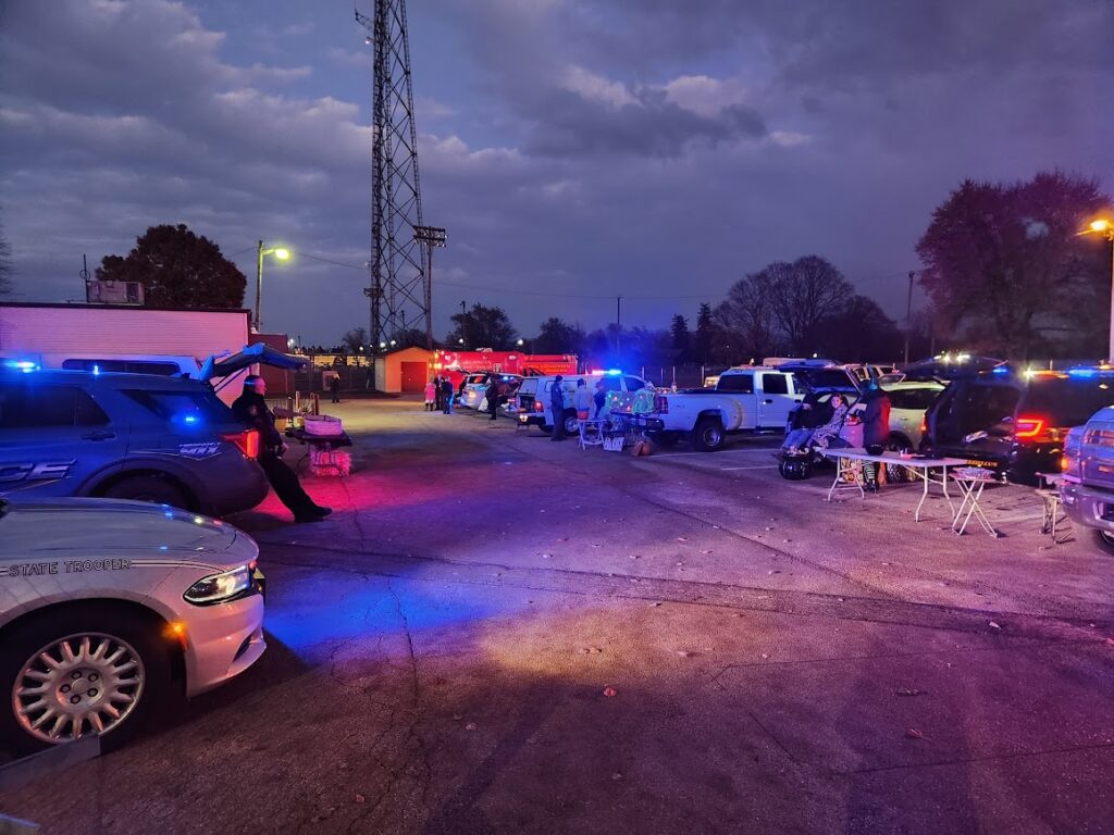 Police and State Trooper vehicles lined up with flashing lights during our 2022 Trunk or Treat event.