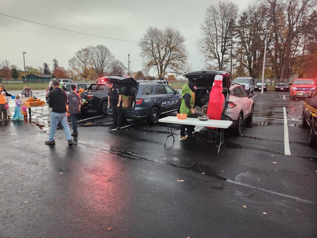 Families trick-or-treating from decorated vehicles alongside local law enforcement at our 2024 Trunk or Treat event.
